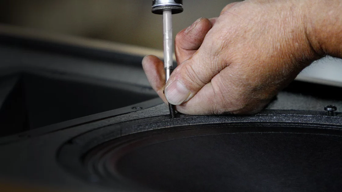 Klipsch Cornwall IV Craftsman hand fastening a speaker to its cabinet